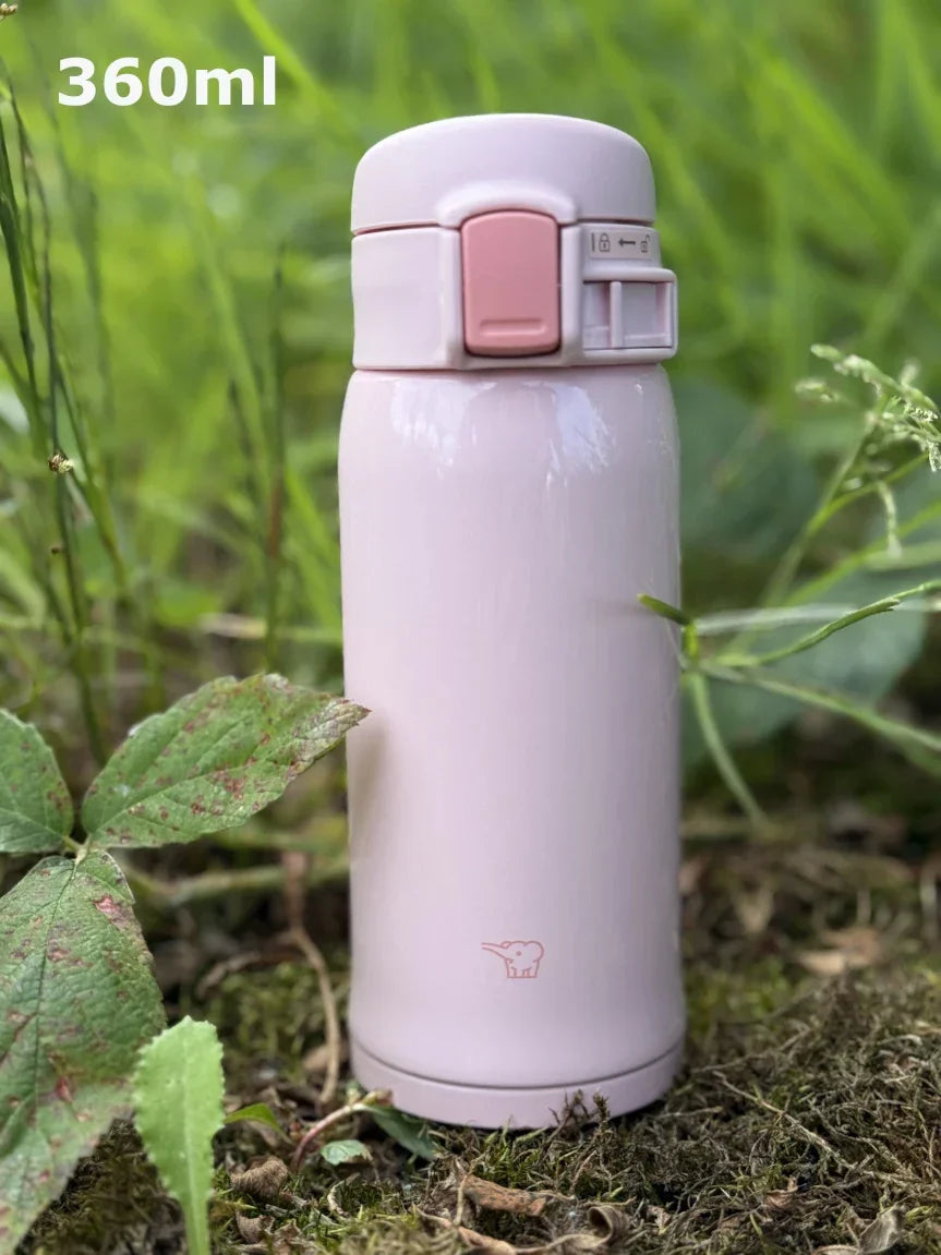 Zojirushi SM-SR60 Pink Travel Mug – 360 ml stainless steel insulated bottle with flip-top lid, BPA-free, outdoors photo on grass.